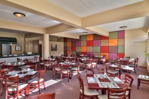 un restaurante con mesas y sillas y una pared colorida en Gonubie Hotel, en Gonubie