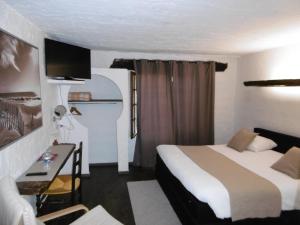 a hotel room with a bed and a desk at Le Relais Des Vieilles Postes in Les Avenières