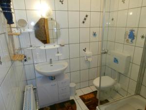 a white bathroom with a sink and a toilet at Uschi's Familienparadies in Monschau