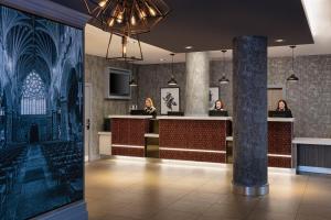 a lobby with three women sitting at a bar at Leonardo Hotel Exeter - Formerly Jurys Inn in Exeter