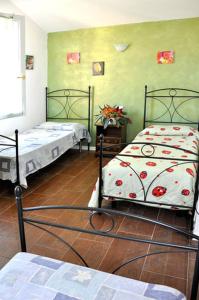 2 camas en una habitación con paredes verdes en Locanda del Lupo, en Faenza