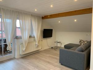 a living room with a couch and a flat screen tv at Ferienwohnung Jauß in Baierbrunn