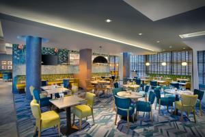 a rendering of a restaurant with tables and chairs at Leonardo Hotel Swindon in Swindon