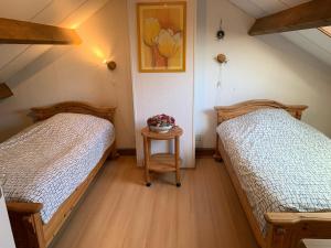 a bedroom with two beds and a table with flowers on it at Rustig gelegen vakantiebungalow in Kortgene