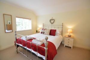 a bedroom with a bed with a red blanket and a window at September Sea in Port Isaac