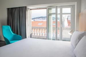 a bedroom with a white bed and a large window at Stay Hotel Lisboa Centro Chiado in Lisbon