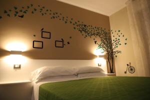 Un dormitorio con una cama verde con pájaros en la pared en Tre Fontane, en Reggio Calabria
