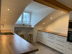an attic kitchen with white cabinets and a counter top at Ferienwohnung Jauß in Baierbrunn