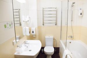 a bathroom with a toilet and a sink and a tub at Optima Sumy in Sumy