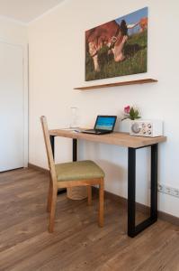 a desk with a laptop and a chair in a room at Ferienwohnungen Trinkl in Bad Wiessee