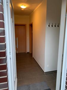 um corredor com uma porta e um piso de azulejo em Ferienwohnung Franke em Ahaus