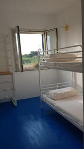 a room with two bunk beds and a window at villa Lùmar fronte mare in Pachino