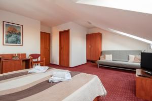 a hotel room with two beds and a couch at Penzión Borievka in Poprad +10 photos