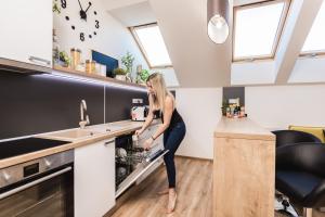 a woman is standing in an oven in a kitchen at FLEXIHOME SK - Komenskeho - private parking spot - ultra modern and stylish in Košice