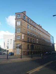 un grand bâtiment en briques au coin d'une rue dans l'établissement Spire Accommodations Ltd, à Bradford