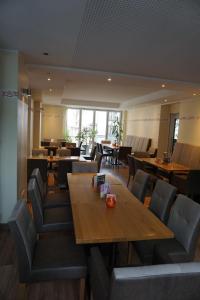 un restaurante con mesas y sillas de madera y ventanas en Hotel-Restaurant Weinhaus Grebel, en Coblenza