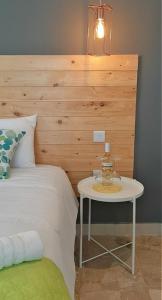 um quarto com uma cama com uma mesa ao lado em CARO Boutique Guest House em San Ġwann