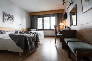 um quarto de hotel com duas camas e uma secretária em Lapland Hotels Hetta em Enontekiö