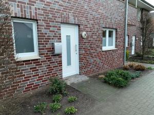 a brick building with a white door on it at Ferienwohnung Franke in Ahaus