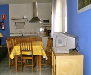 una cocina con una mesa y un ordenador en una encimera en Apartamentos El Castañar, en Hervás