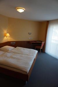 Pokój hotelowy z łóżkiem i biurkiem w obiekcie Hotel-Restaurant Weinhaus Grebel w Koblencji
