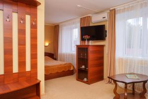 a hotel room with a bedroom with a bed and a television at Hotel Vologda in Vologda