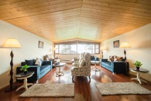 西姆拉的住宿－Holiday In Homestay，客厅配有蓝色的家具和木制天花板