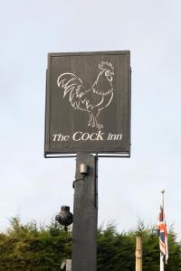 un cartel con un gallo en un poste en The Cock Inn Hotel en Sheering