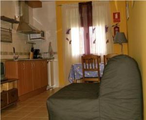 a living room with a bed and a kitchen at Apartamentos El Castañar in Hervás