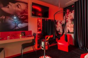 a room with red walls and a red room with a table and chairs at Motel Emoções in Nogueira da Regedoura