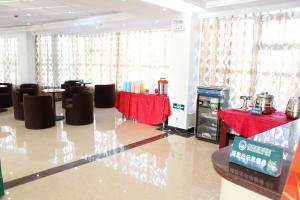 HejialiangにあるGreenTree Inn Lanzhou Zhongchuan Airport Business Hotelの椅子とテーブル、赤いテーブルクロスが備わる部屋