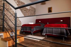 two beds in a loft bedroom with a staircase at Il Carro Comfortable Rooms in San Giovanni Gemini
