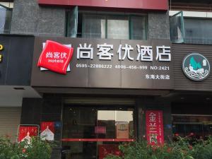 Thank Inn Chain Hotel fujian quanzhou fengze district donghai street في تشيوانتشو: مبنى عليه لافته