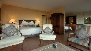 um quarto com uma cama e 2 cadeiras em Kingston Place Guesthouse em Durban