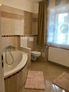 a bathroom with a tub and a toilet and a sink at Apartment Jasmine in Passail