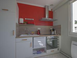 a small kitchen with a sink and a stove at Comfortable apartment facing the museum in Arromanches-les-Bains