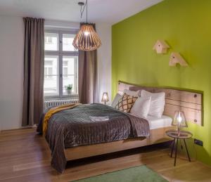 a bedroom with a bed and a green wall at 4 Trees Apartments by Adrez Living in Prague