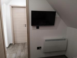 TV de pantalla plana en una pared junto a una puerta en APP Aleksa 6168, en Čatež ob Savi