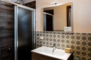 a bathroom with a sink and a shower and a mirror at Il Carro Comfortable Rooms in San Giovanni Gemini