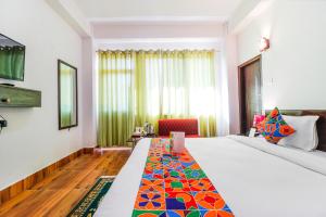 um quarto de hotel com uma cama e uma cadeira em FabHotel Greenery View Middle Lingding ICAR Road em Gangtok