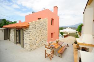 an external view of a house with a table and chairs at Hawk Villa, nature essence, By ThinkVilla in Yerakárion