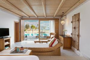 a living room with a bed and a view of a pool at Mitsis Selection Blue Domes in Kardamaina