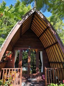 Cabaña de madera pequeña con techo de paja en Meno Madia Bungalows, en Gili Meno