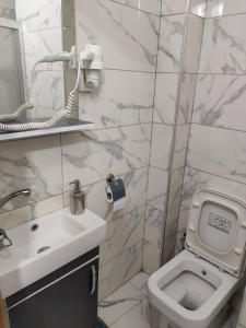 La salle de bains blanche est pourvue d'un lavabo et de toilettes. dans l'établissement Moon Hotel Şirinevler, à Istanbul