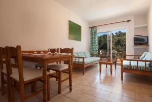 a living room with a dining room table and chairs at PINOS ALTOS 03 in Cala de Sant Vicent