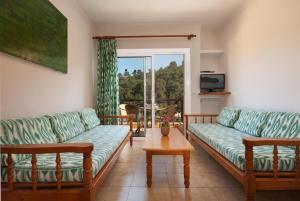 a living room with two couches and a table at PINOS ALTOS 11 in Cala de Sant Vicenc