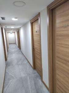 einen Flur mit Holztüren in einem Gebäude in der Unterkunft Moon Hotel Şirinevler in Istanbul
