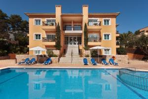 a hotel with a swimming pool in front of a building at PINOS ALTOS 11 in Cala de Sant Vicenc