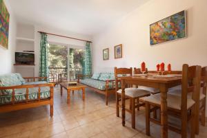 a living room with a table and chairs and a couch at PINOS ALTOS 09 in Cala de Sant Vicenc