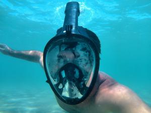 a man in the water with a diver helmet on his face at Gênesis Beach Hostel! Quartos compartilhados e privativos na Pinheira in Palhoça